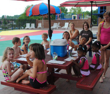 Photo of children sitting at a table enjoying camp activities
